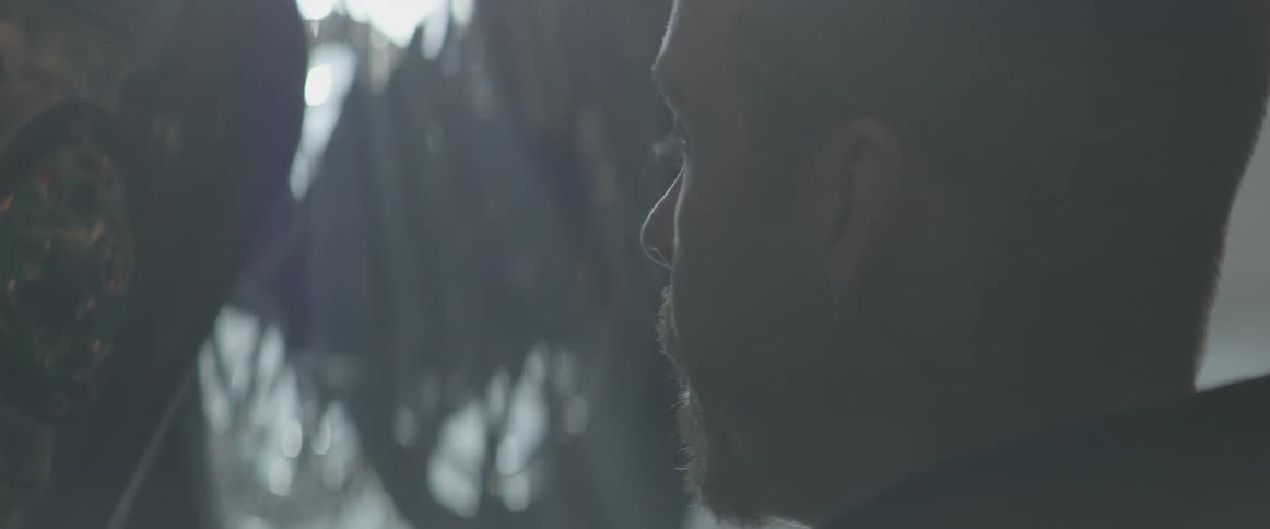 A man is sitting in a garage looking at wheels