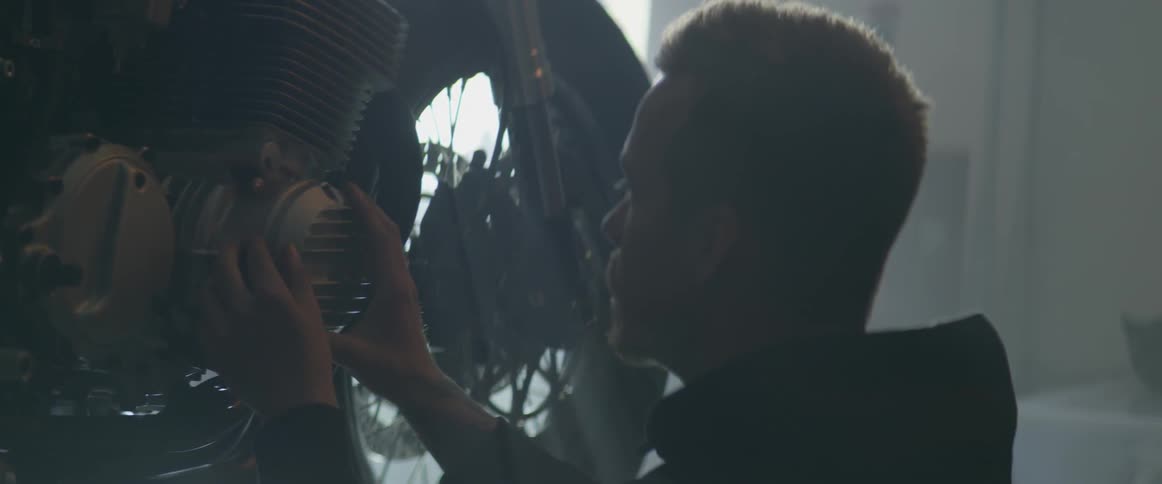 A man is working on his motorcycle in the garage