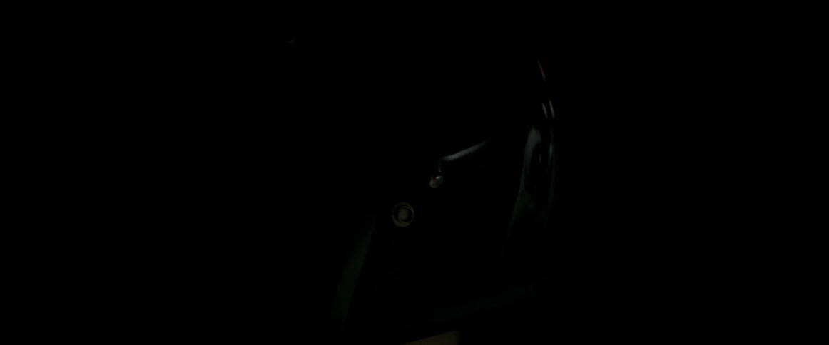 A beam of light is moving across a man wearing a motorcycle helmet