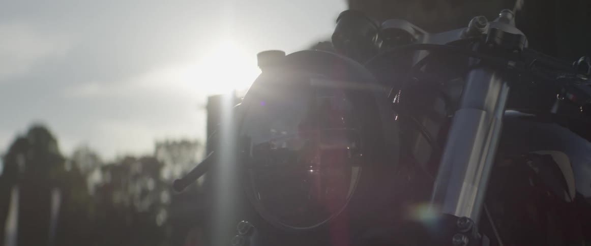 The sun shines onto a parked motorcycle