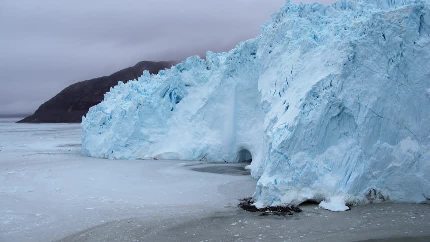 A large iceberg is melting over a cave entrance in the middle