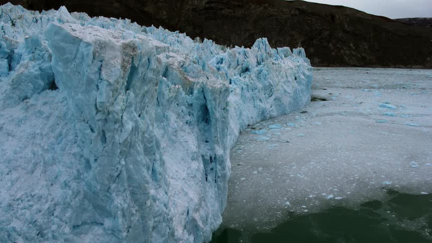 Icebergs tower on the side of water