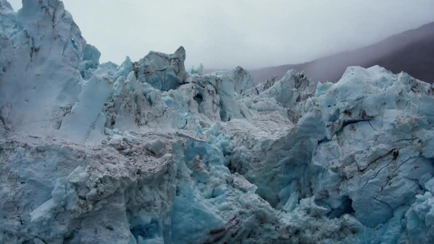 A tall ice formation towers over the water