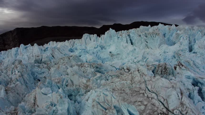 Tall blue iceberg formations tower over the water