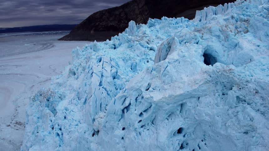 There is a small dark cave in this large iceberg