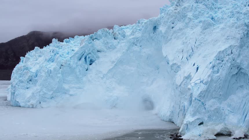The iceberg is melting rapidly pouring ice into the water