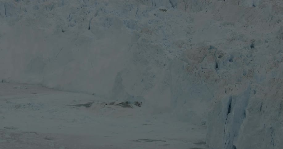 An iceberg is collapsing into the ice covered water