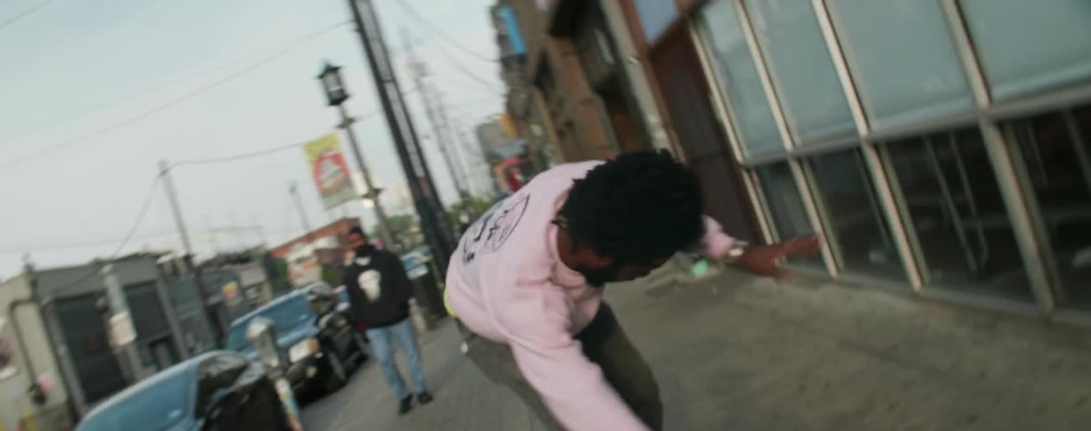 A man is doing jumps on his skateboard on the sidewalk