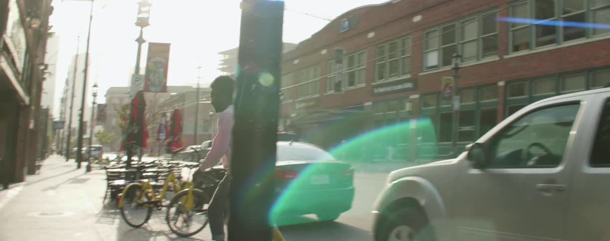 A man riding his skateboard briefly falls off on the sidewalk