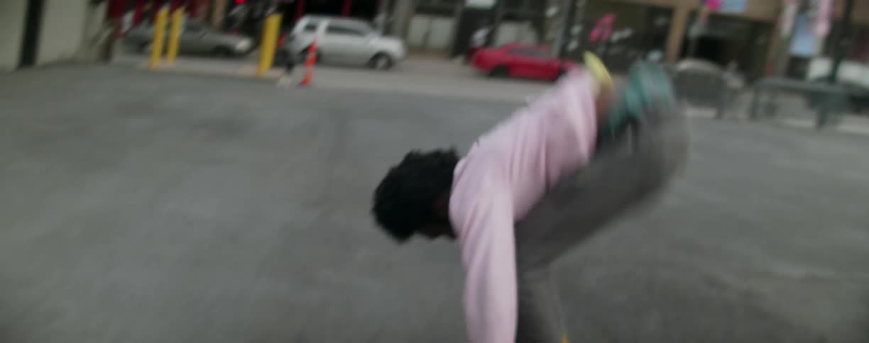 A man is skateboarding and doing some tricks in a parking lot