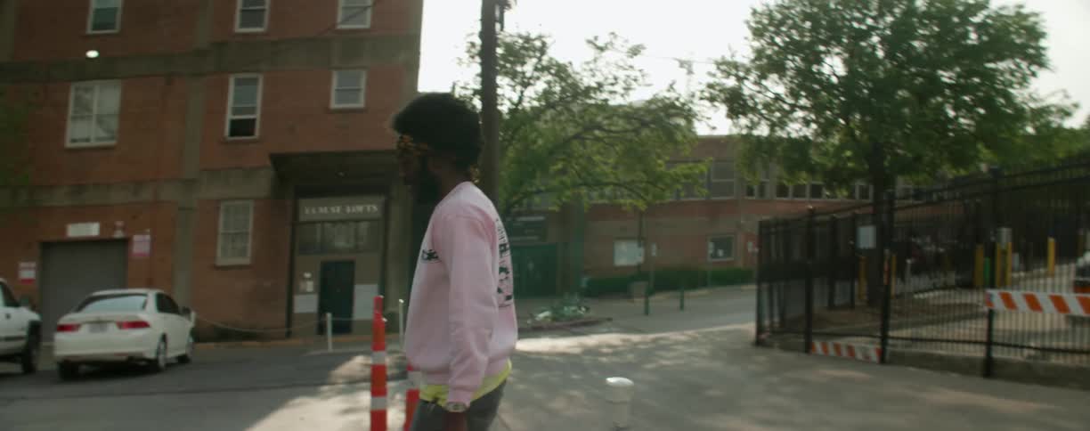 A man picks up then rides a skateboard outside in the city during the day