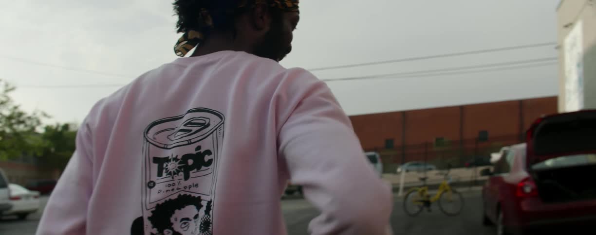 A black man walks around outside of a building