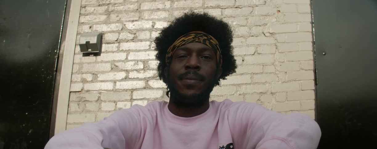 A man is sitting on porch steps looking at the camera