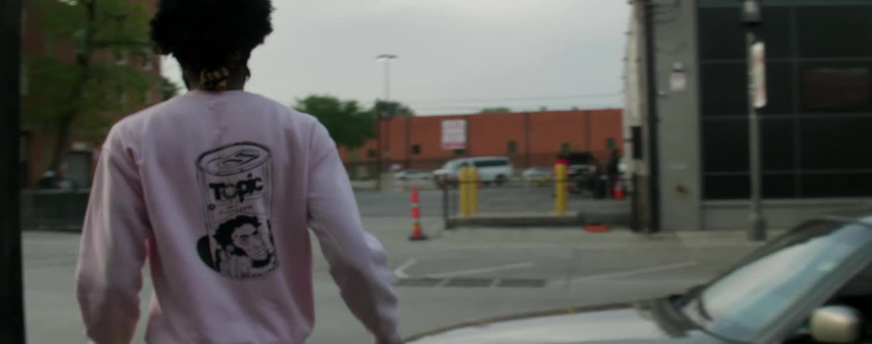 A man in a white sweatshirt crosses a street
