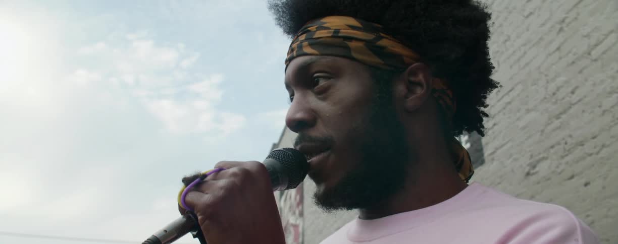 A man is talking on a microphone on a cloudy day
