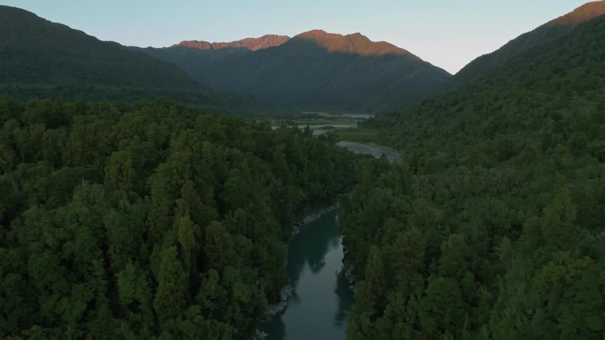 Stream flowing through trees and mountains