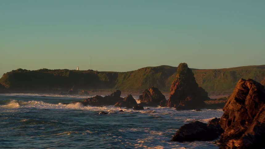 The rough waters are crashing against the shore