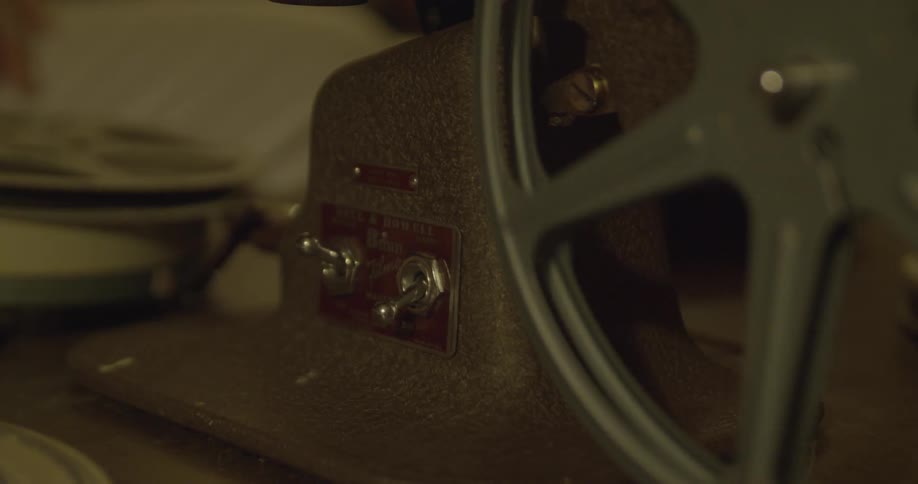 Close up of a hand operating a film projector