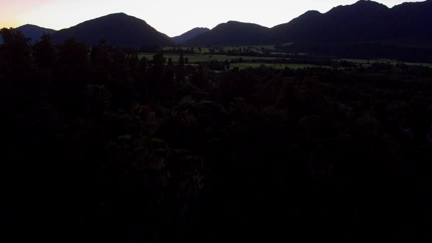 River flows near mountains at sunset