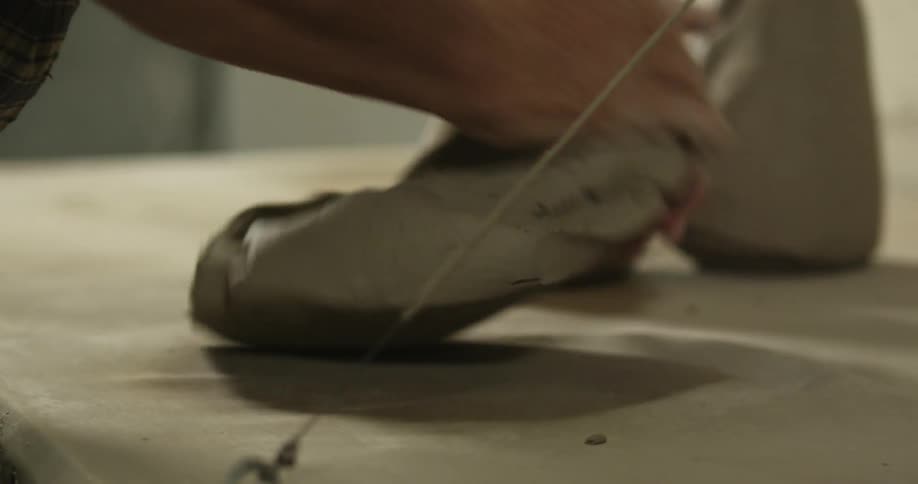 A man kneads a ball of clay