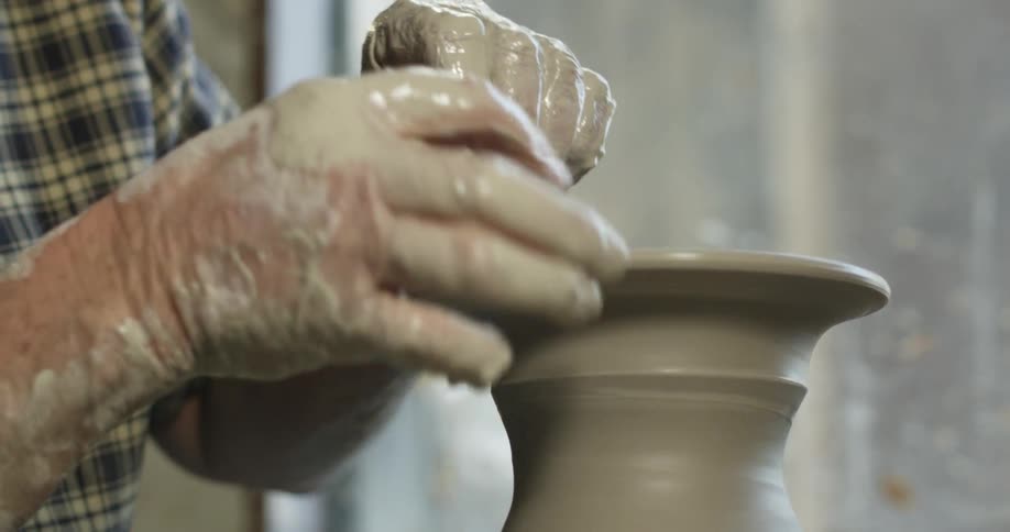 A man is making a pot out of clay