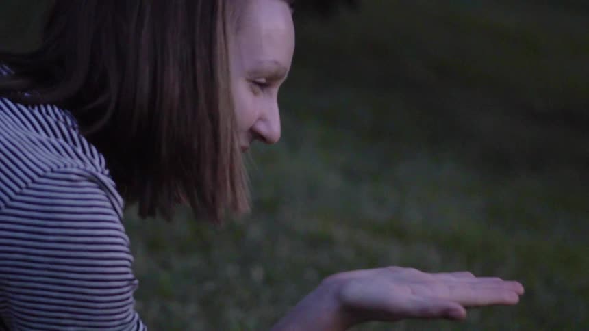 Woman smiles as she holds a bug
