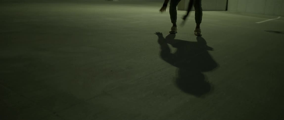 A person dances in a dim room
