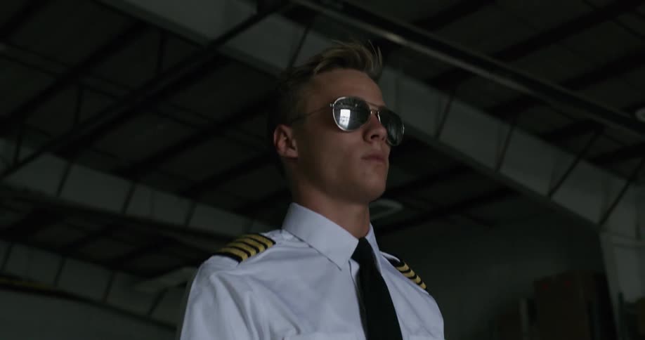 A pilot walks in a hangar