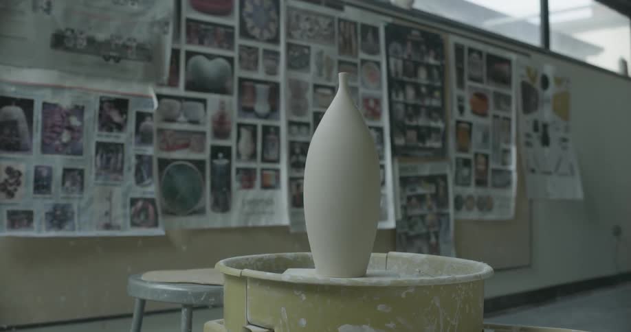 A clay vase is drying on a stand