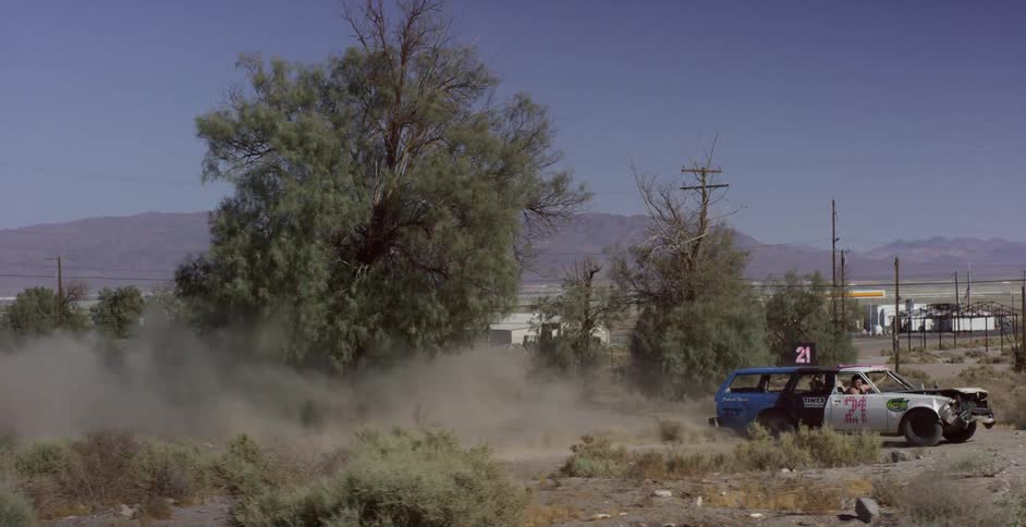 The car is winding around the dirt field