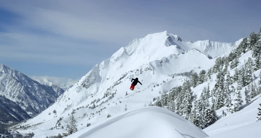 Skier jumps through the air in snowy mountains