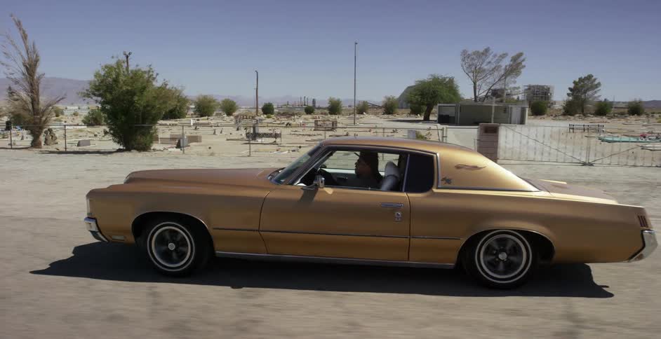 A person drives a nice car down the desert road