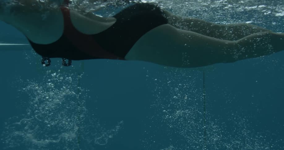 A woman is swimming in the pool fast