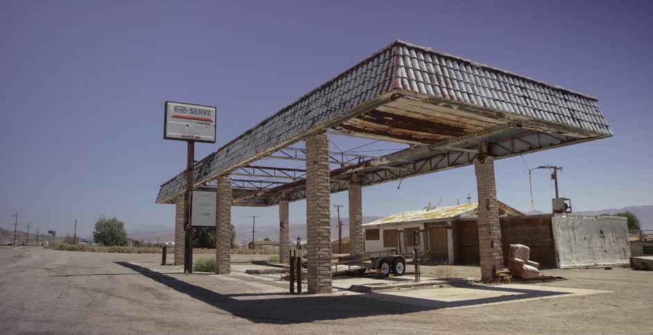A collapsing abandoned gas station next to a highway