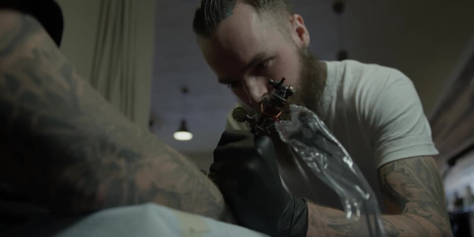 A man is giving a tattoo in a parlor