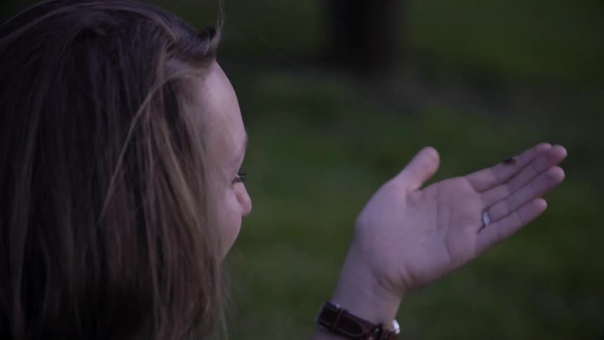 Woman holds an insect on her index finger