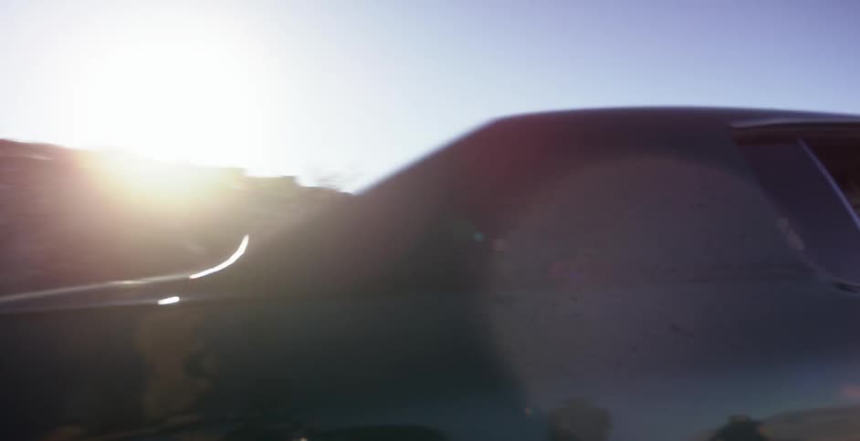 A car is traveling down a desert road