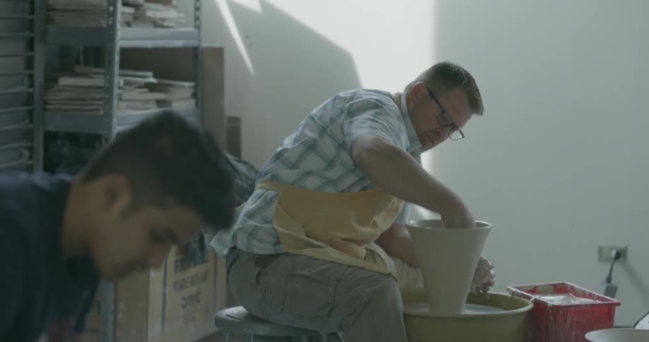 A couple of men are making pottery