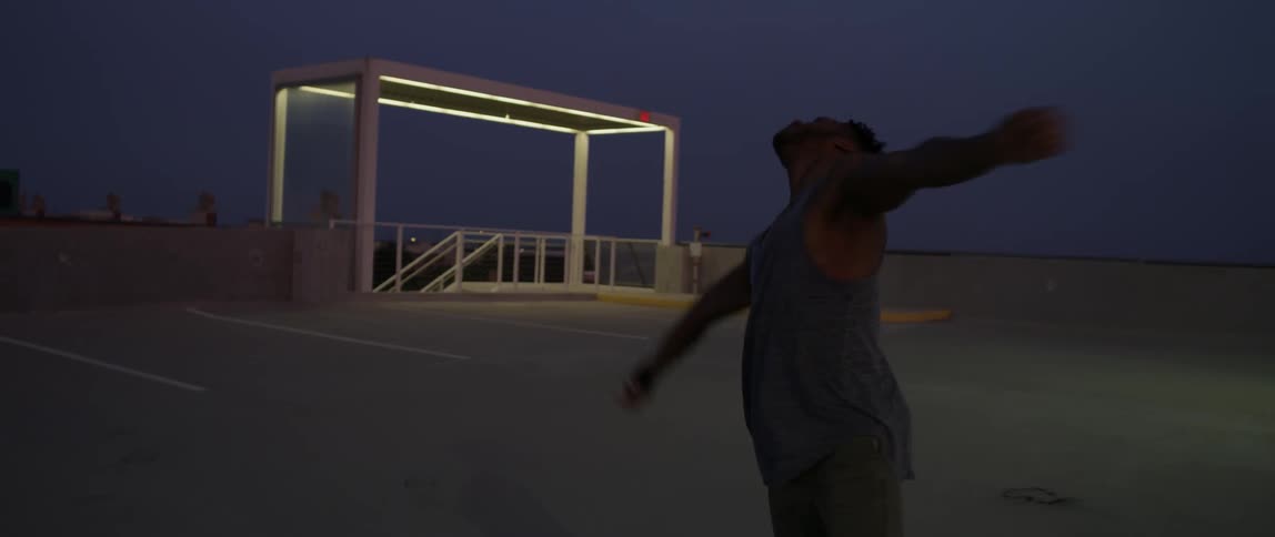 Man dances in a city parking lot