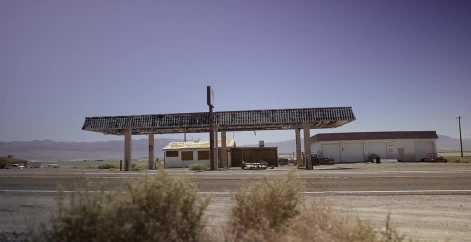 An gas station sits abandoned in a desert town
