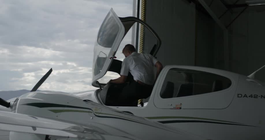 A man climbs up on a plane to get in the cabin