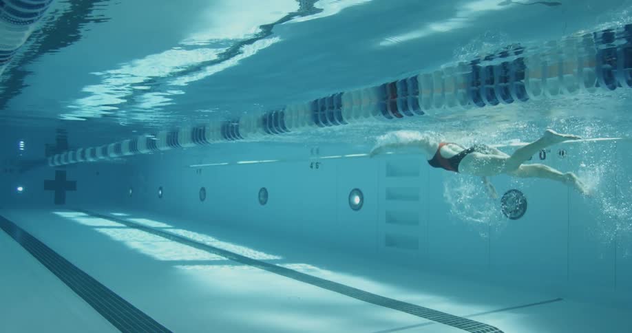 A woman swims in the blue water of the pool