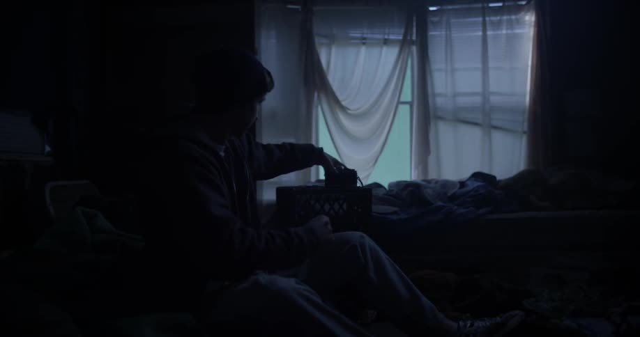 Man doing something with an item in a dimly lit room