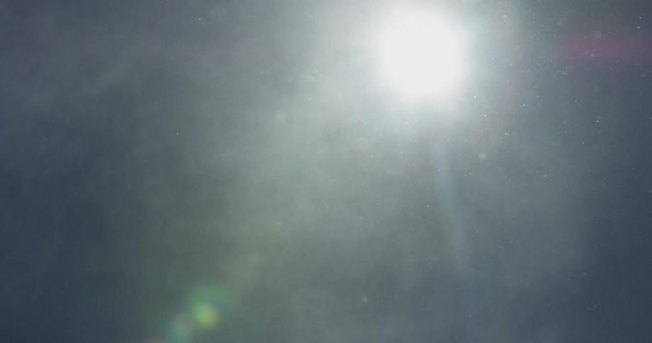 Snow falls from the sky on a sunny day