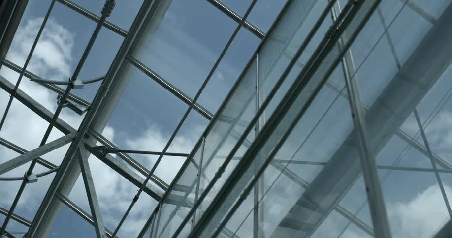 A glass ceiling is letting the light in from a cloudy sky