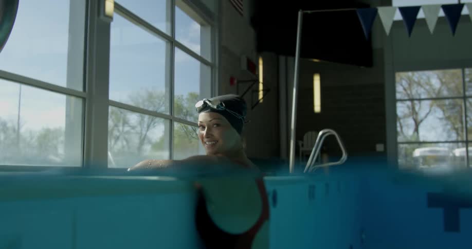 A woman is standing in a pool smiling