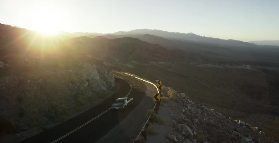 A hot rod travels down a winding mountain road