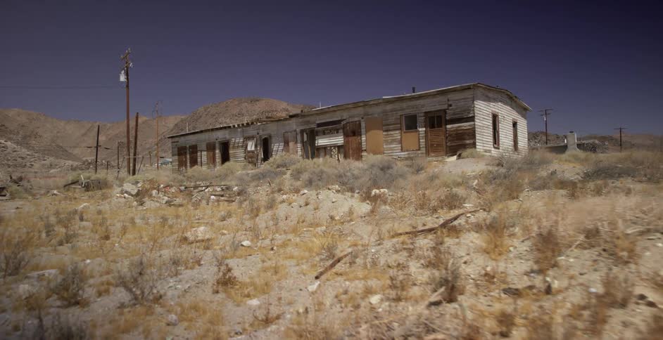 A building sets abandoned and crumbling in the desert