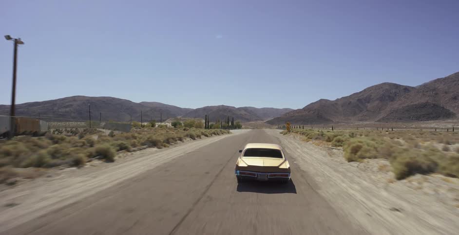 Car drives on rural road near a train
