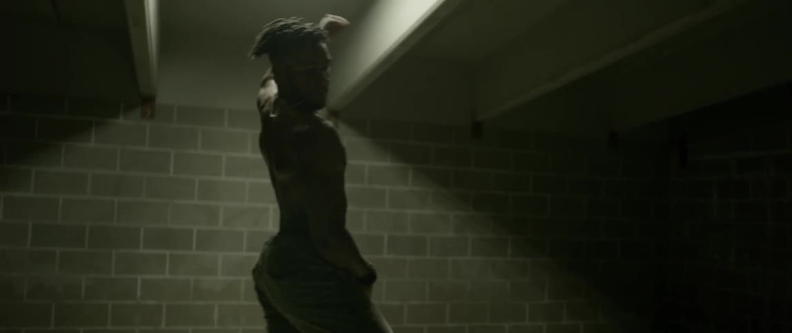 A man dances in a brick room